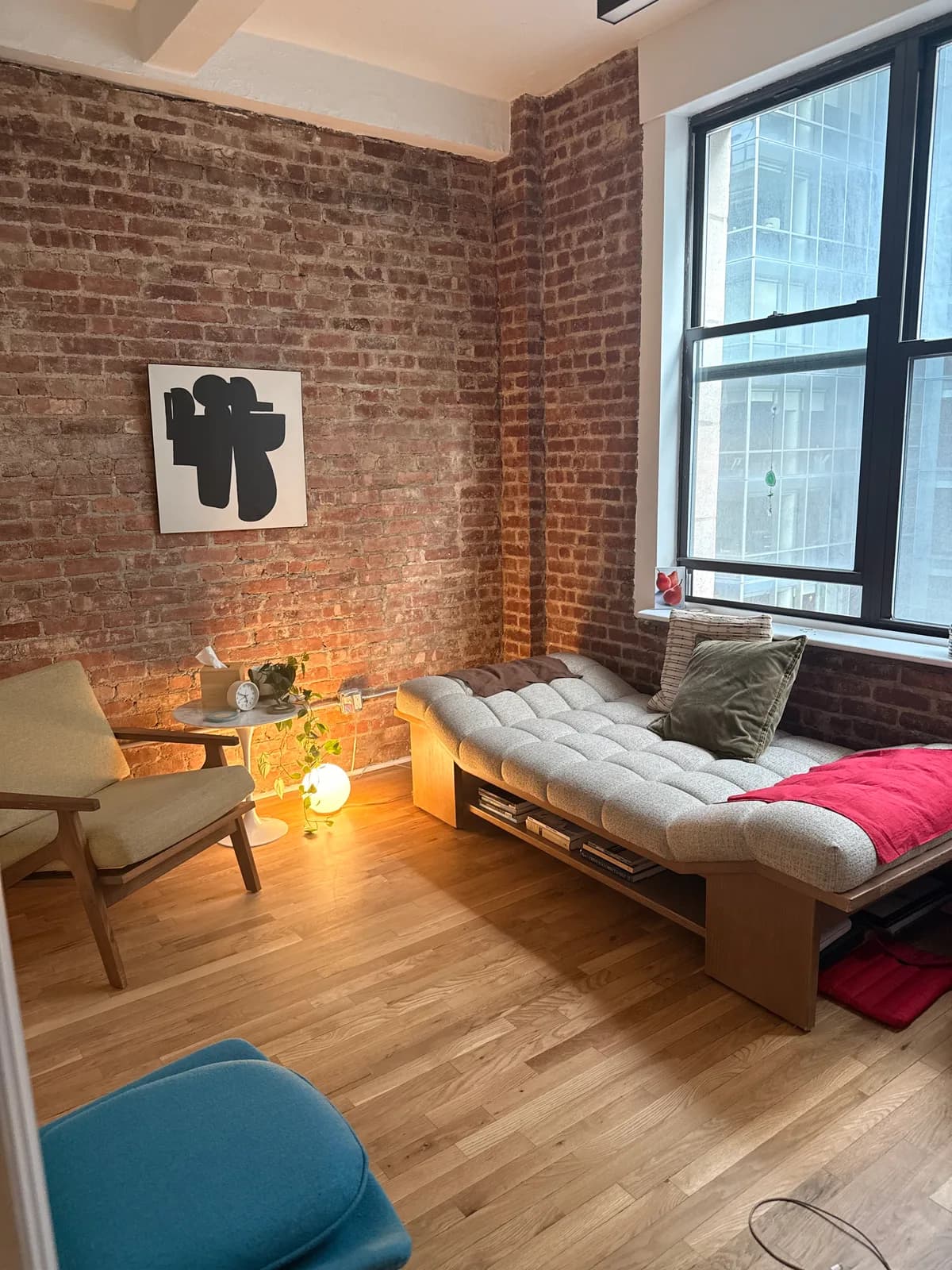 Therapy room with exposed brick walls, a daybed, and a soft floor lamp